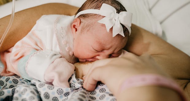 A touching scene of a newborn baby breastfeeding, symbolizing innocence and motherhood.