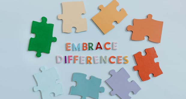 Colorful puzzle pieces surrounding 'embrace differences' text, symbolizing diversity and unity.